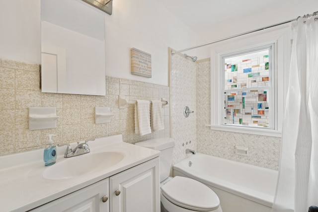 full bathroom with vanity, toilet, tile walls, and shower / bath combo