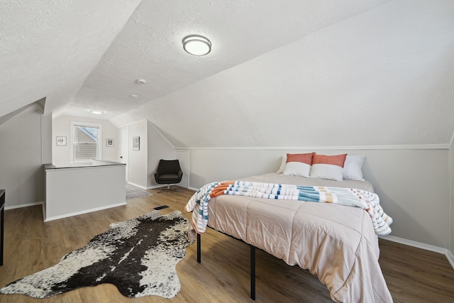 bedroom featuring vaulted ceiling, a textured ceiling, and light wood-type flooring