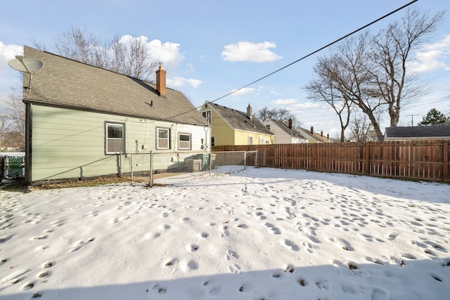 view of snow covered rear of property