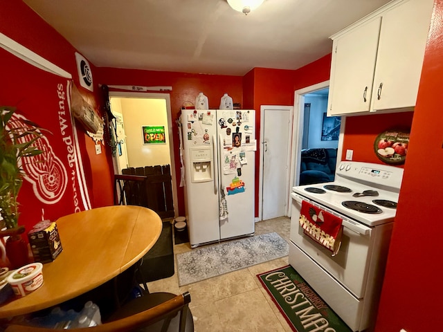 kitchen featuring light tile patterned floors, white cabinets, and white appliances