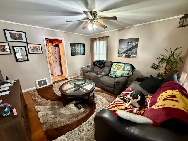 living room featuring hardwood / wood-style flooring, ornamental molding, and ceiling fan