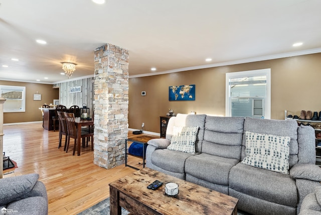 living room with decorative columns, ornamental molding, and hardwood / wood-style flooring