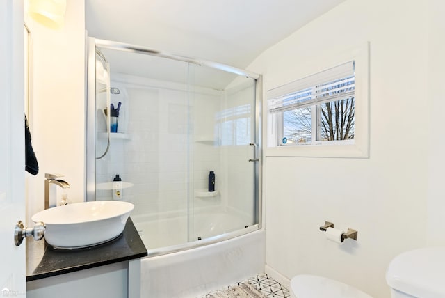 full bathroom featuring combined bath / shower with glass door, sink, tile patterned floors, and toilet