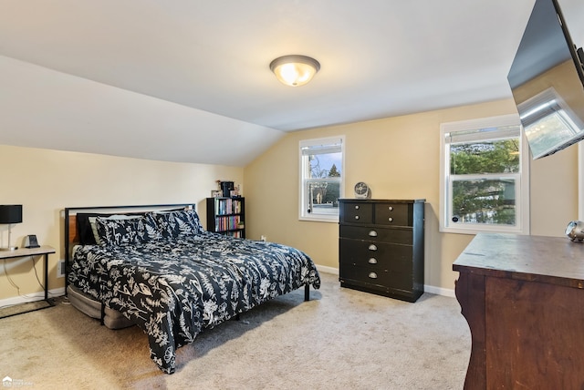 carpeted bedroom featuring lofted ceiling and multiple windows