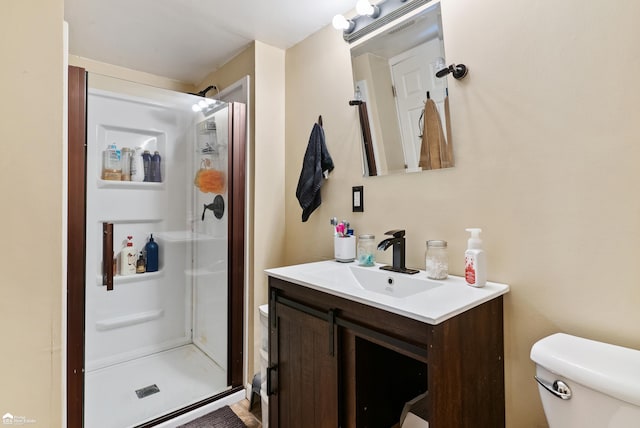 bathroom featuring vanity, toilet, and an enclosed shower