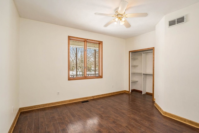 unfurnished bedroom with ceiling fan, dark hardwood / wood-style flooring, and a closet