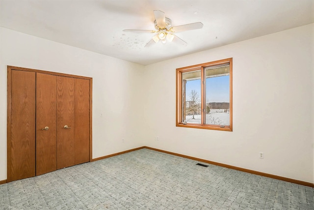 unfurnished bedroom with ceiling fan and a closet