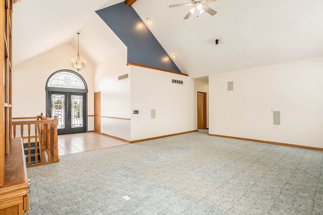 foyer entrance with light tile patterned floors, ceiling fan with notable chandelier, high vaulted ceiling, and french doors