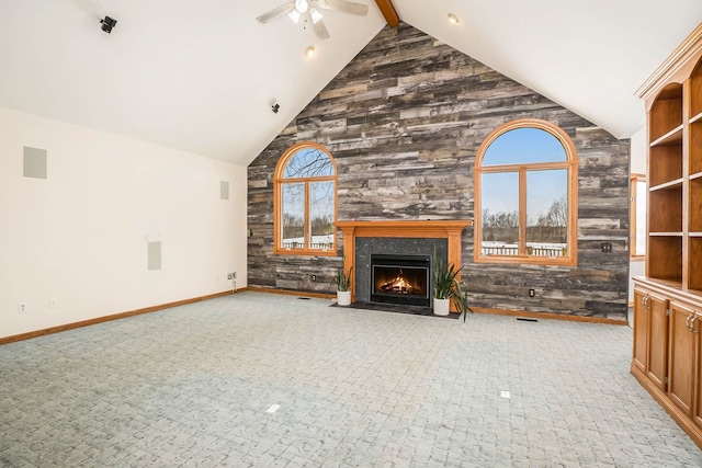 unfurnished living room with beamed ceiling, ceiling fan, plenty of natural light, and high vaulted ceiling