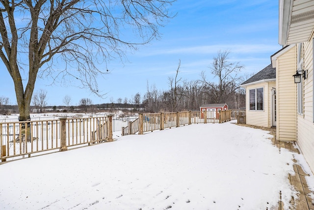 snowy yard with a storage shed