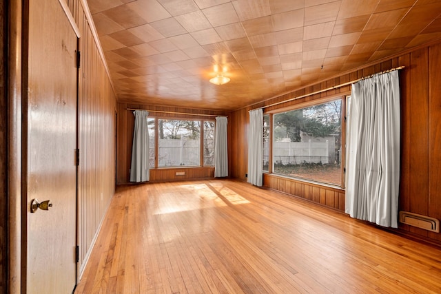 interior space featuring light wood-type flooring and wood walls