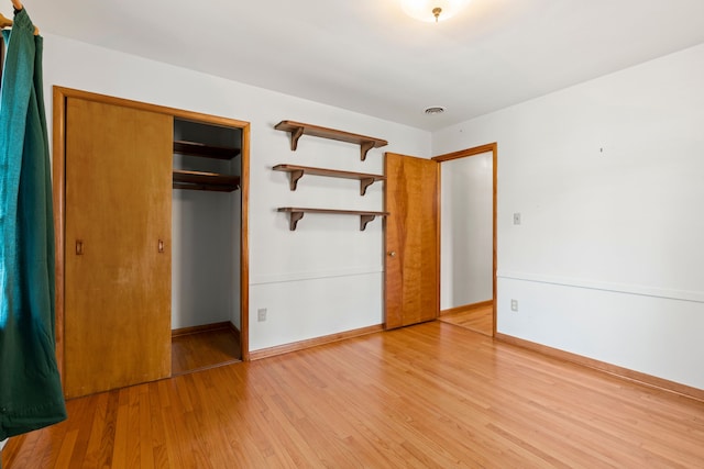 unfurnished bedroom featuring light wood-type flooring and a closet