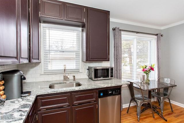 kitchen featuring a healthy amount of sunlight, appliances with stainless steel finishes, sink, and crown molding