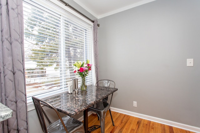 dining area featuring ornamental molding and light hardwood / wood-style floors