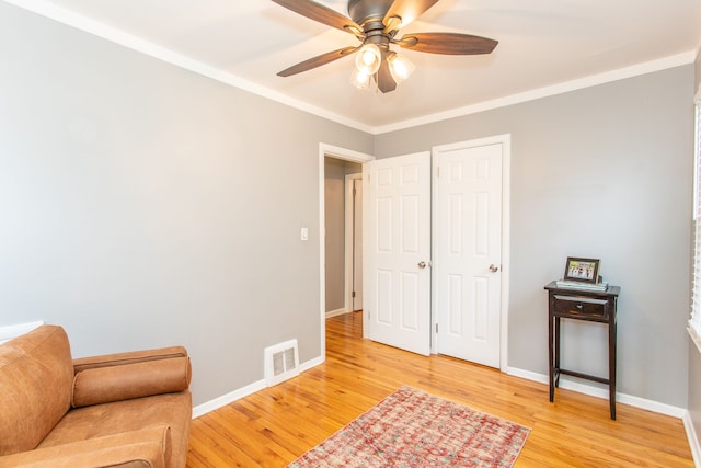 sitting room with crown molding, ceiling fan, and light wood-type flooring