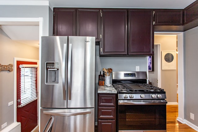 kitchen featuring stainless steel appliances, dark brown cabinetry, and light hardwood / wood-style floors