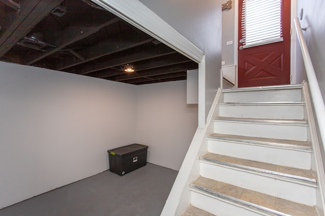 stairs featuring concrete flooring