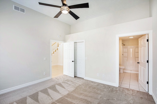 unfurnished bedroom with light colored carpet, ceiling fan, and ensuite bathroom