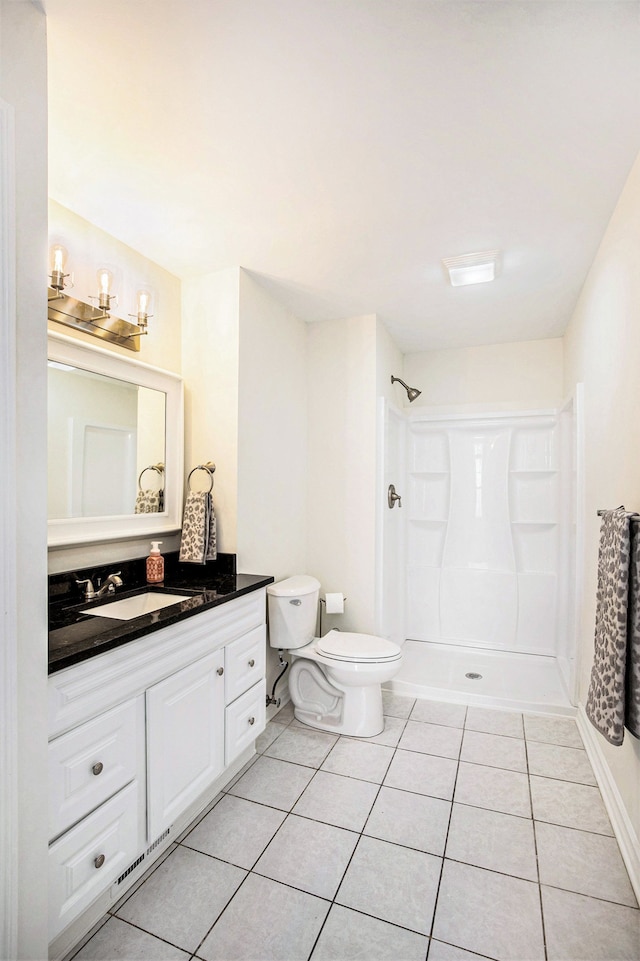 bathroom featuring vanity, walk in shower, tile patterned floors, and toilet