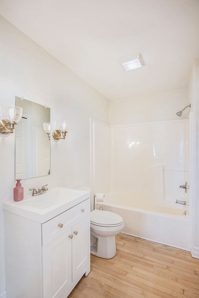 full bathroom with hardwood / wood-style flooring, shower / tub combination, vanity, and toilet