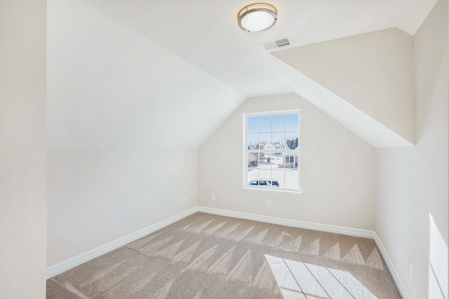 bonus room featuring lofted ceiling and light carpet