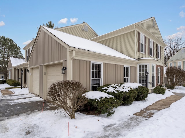 snow covered property featuring a garage