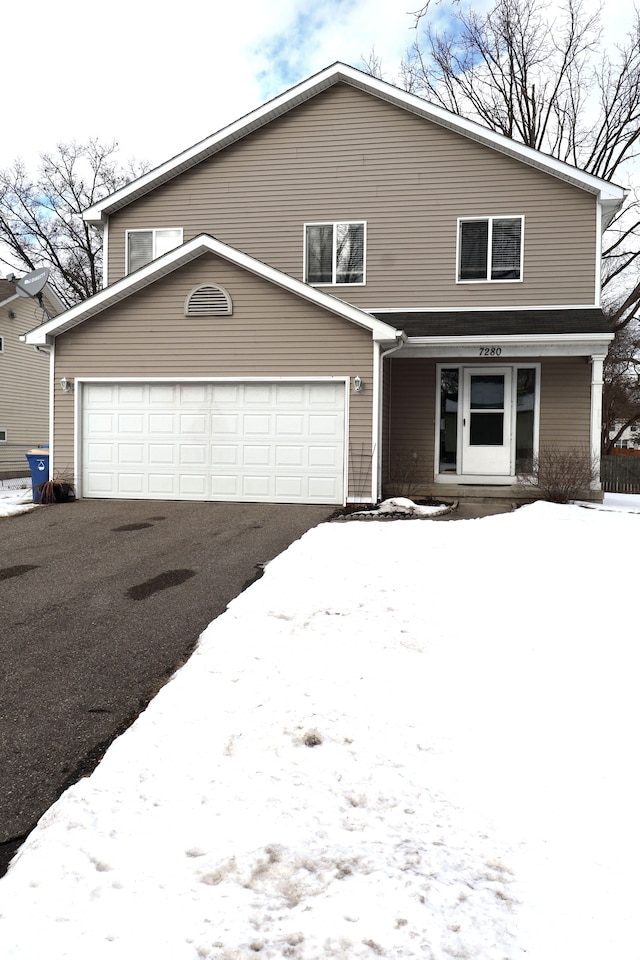 view of front facade featuring a garage and aphalt driveway