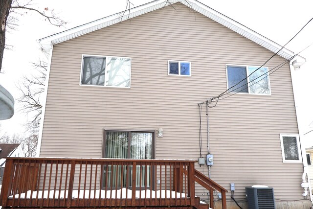 rear view of property featuring central AC and a wooden deck