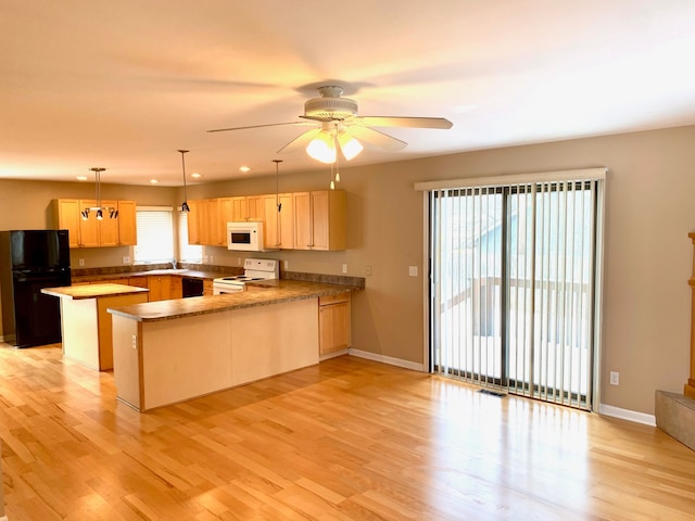 kitchen featuring light brown cabinets, a peninsula, ceiling fan, light wood finished floors, and black appliances