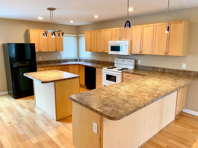 kitchen with black appliances, a peninsula, light brown cabinetry, and a sink