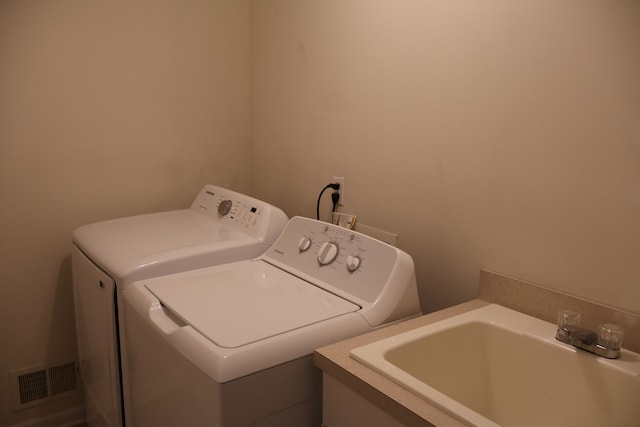 washroom with washer and dryer, laundry area, visible vents, and a sink