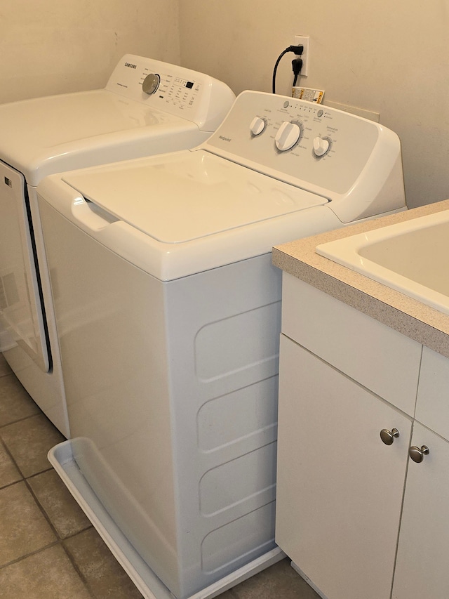 laundry room with cabinet space, separate washer and dryer, and tile patterned flooring