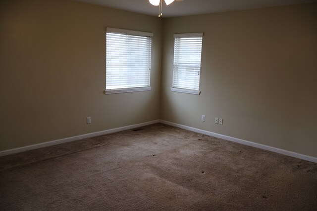 carpeted empty room with baseboards and ceiling fan