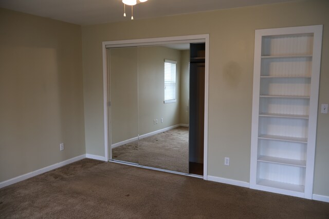 unfurnished bedroom with a closet, baseboards, and carpet