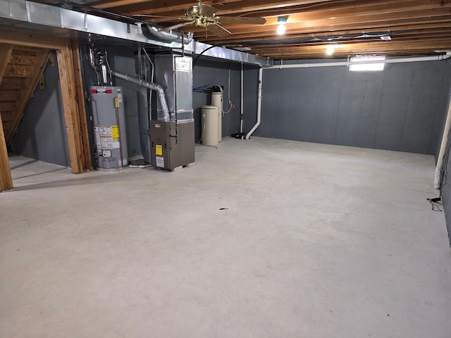 below grade area featuring stairs, gas water heater, and heating unit