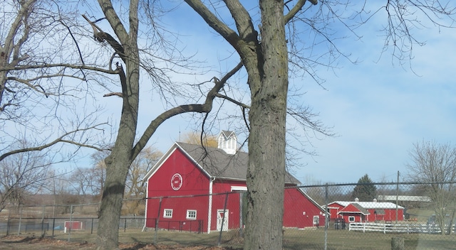 view of barn featuring fence