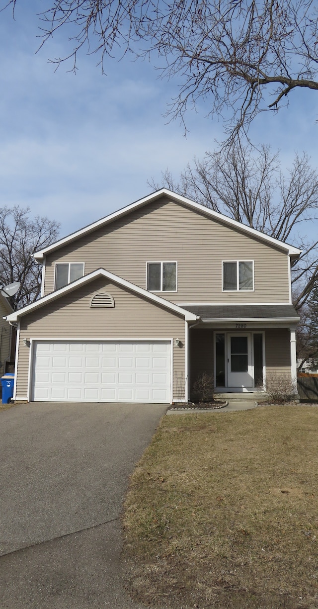 view of front facade with a garage, driveway, and a front yard