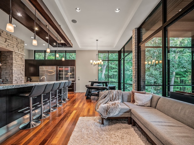 living room with hardwood / wood-style flooring, a wealth of natural light, and an inviting chandelier