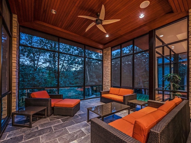 sunroom featuring ceiling fan and wood ceiling