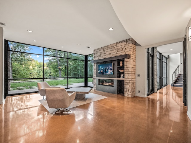 living room with a wall of windows and a stone fireplace