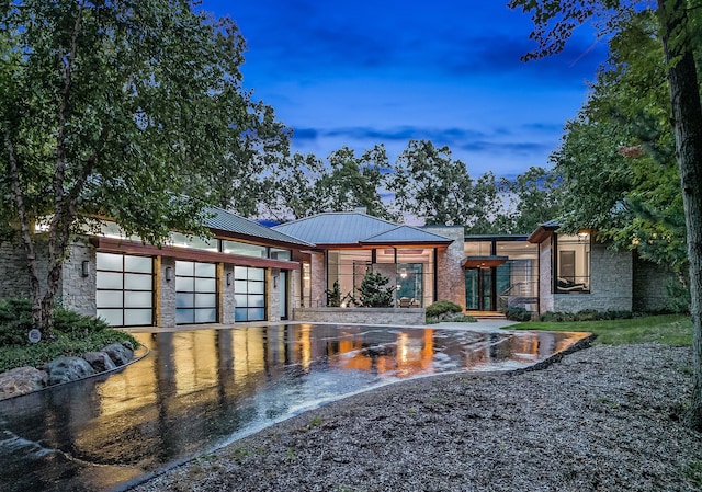 back house at dusk with a garage