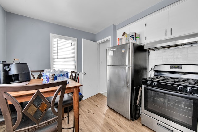 kitchen featuring decorative backsplash, light wood-type flooring, white cabinets, and appliances with stainless steel finishes