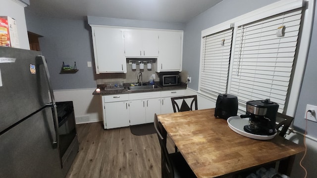 kitchen featuring sink, stainless steel appliances, hardwood / wood-style floors, and white cabinets