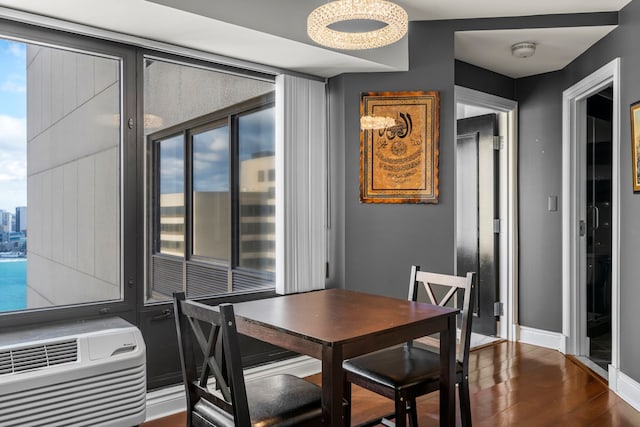 dining space featuring plenty of natural light, dark hardwood / wood-style floors, heating unit, and an AC wall unit