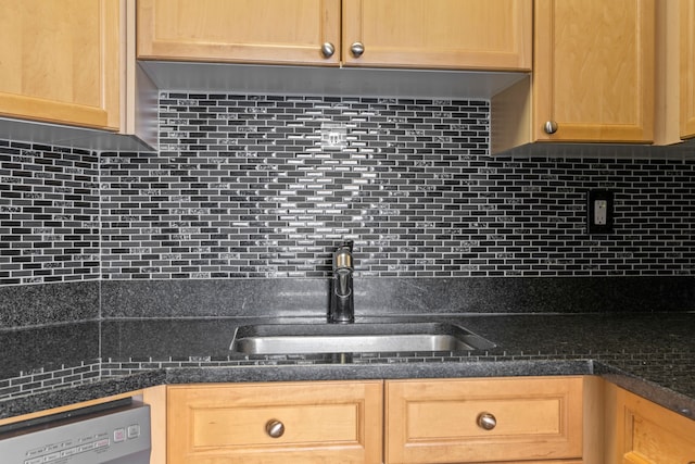 kitchen with dishwashing machine, sink, backsplash, and dark stone counters