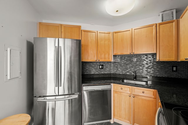 kitchen with sink, dark stone countertops, backsplash, stainless steel appliances, and electric panel