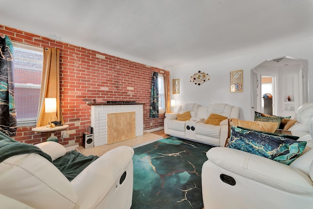 living room with brick wall, a brick fireplace, and a wealth of natural light