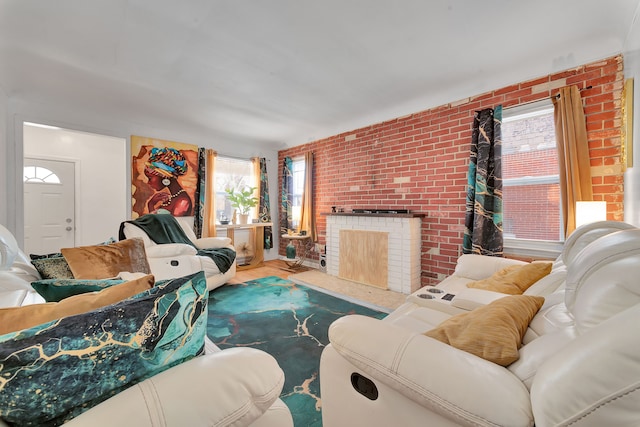 living room featuring a brick fireplace, hardwood / wood-style flooring, and brick wall