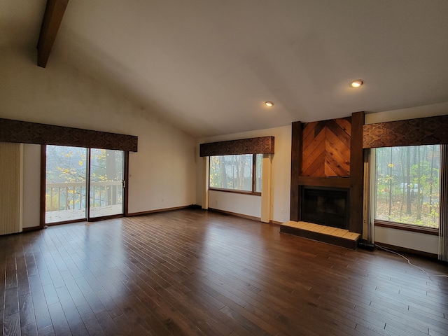 unfurnished living room with dark wood finished floors, beamed ceiling, baseboards, and a large fireplace