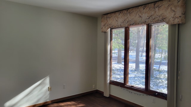 empty room with dark wood finished floors and baseboards